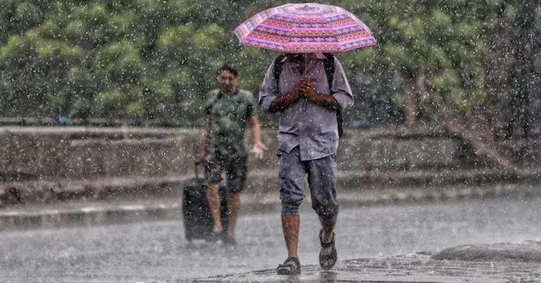 বৃষ্টিতে ছাতা হাতে পথিকের ছবি